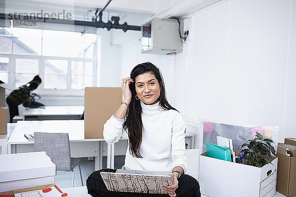 Porträt einer selbstbewussten Geschäftsfrau mit Laptop in einem neuen Büro