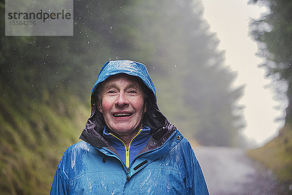 Porträt älterer Mann beim Wandern im Regen