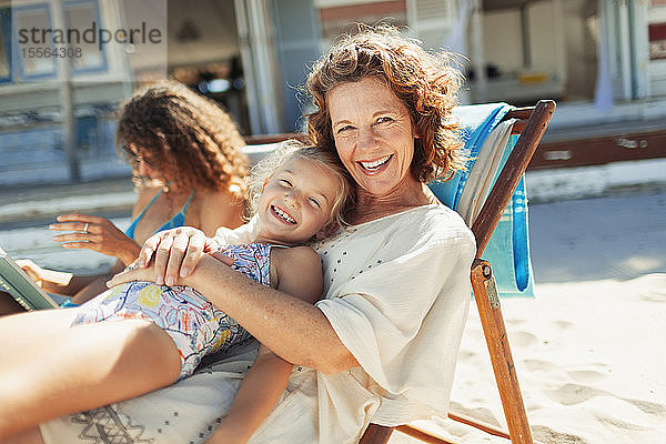 Porträt glückliche Großmutter und Enkelin entspannen am sonnigen Strand