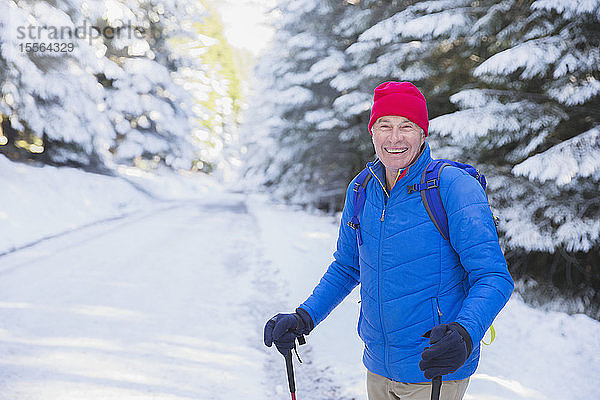 Glücklicher älterer Mann beim Wandern im Schnee