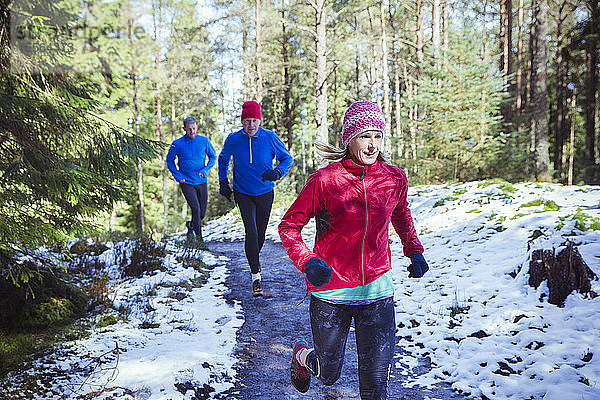 Familie joggt im verschneiten Wald