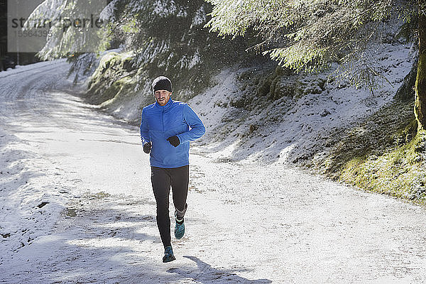 Mann joggt im Schnee