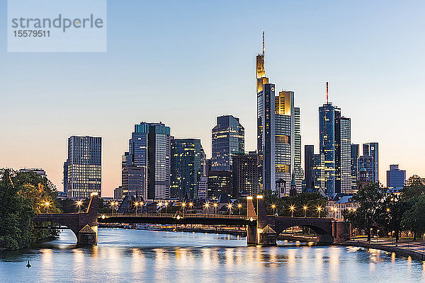 Beleuchtete Brücke über den Fluss gegen klaren Himmel bei Sonnenuntergang in Frankfurt  Deutschland