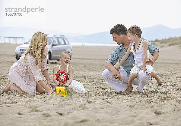 Spanien  Familie spielt am Strand  lächelnd