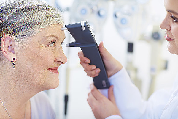 Augenarzt untersucht das Sehvermögen einer älteren Frau