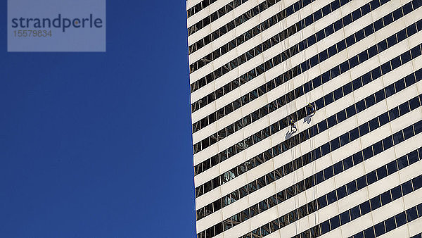 USA  Illinois  Chicago  zwei Fensterputzer  die an der Fassade eines Wolkenkratzers hängen