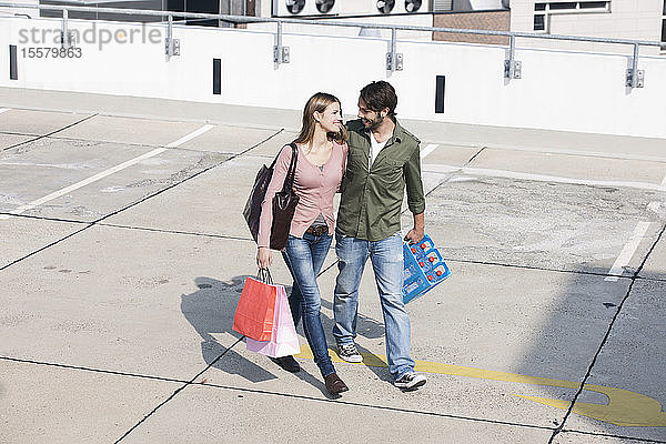 Deutschland  Köln  Junges Paar mit Einkaufstaschen  lächelnd