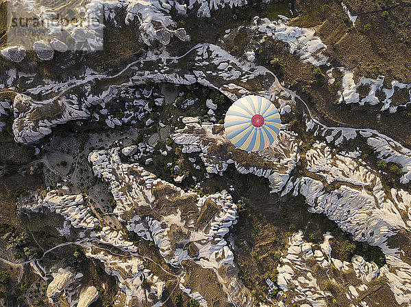Luftaufnahme eines Heißluftballons beim Überfliegen von Felsformationen im Goreme-Nationalpark  Kappadokien  Türkei