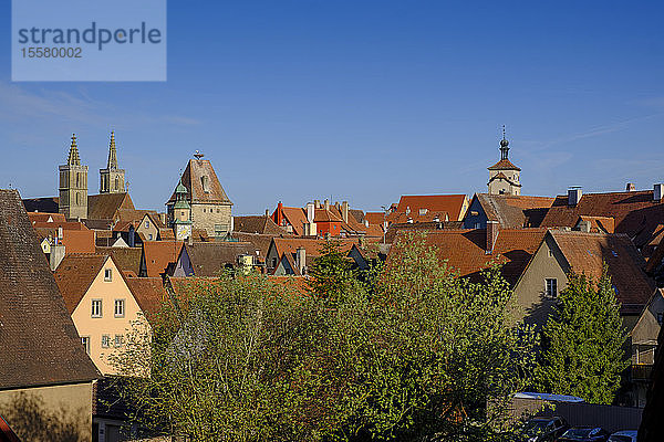 Hochwinkelansicht von Häusern und Rathausturm in Rothenburg gegen blauen Himmel  Bayern  Deutschland