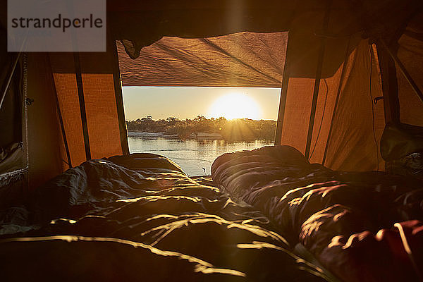 Landschaftliche Ansicht des Flusses bei Sonnenuntergang vom Zelt am Caprivi-Streifen aus gesehen  Namibia