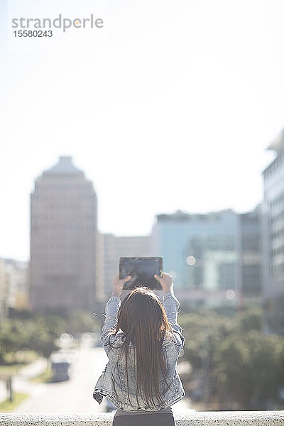 Junge Frau beim Fotografieren mit einem digitalen Tablett  Rückenansicht