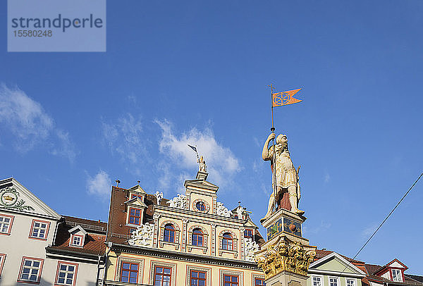 Niedrigwinkelansicht der Rolandstatue und des Renaissance-Gebäudes vor blauem Himmel in Erfurt  Deutschland