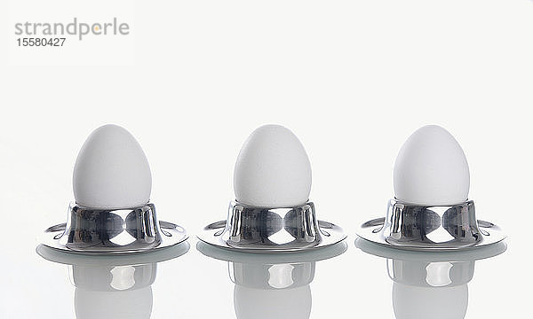 Gekochte Eier im Eierbecher auf weißem Hintergrund