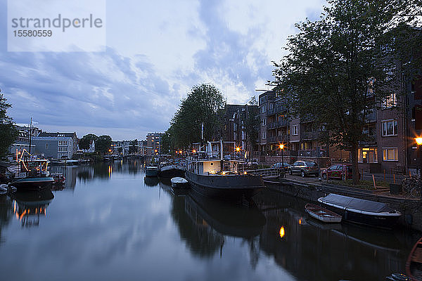 Niederlande  Amsterdam  Blick auf Boote am Stadtkanal und Mehrfamilienhaus im Hintergrund