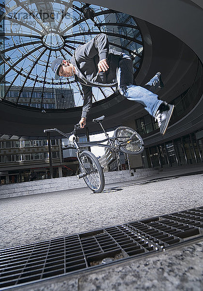 Deutschland  Stuttgart  Junger Mann beim Stunt auf dem Fahrrad