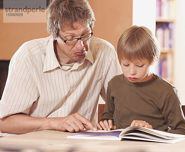 Vater und Sohn lesen Buch