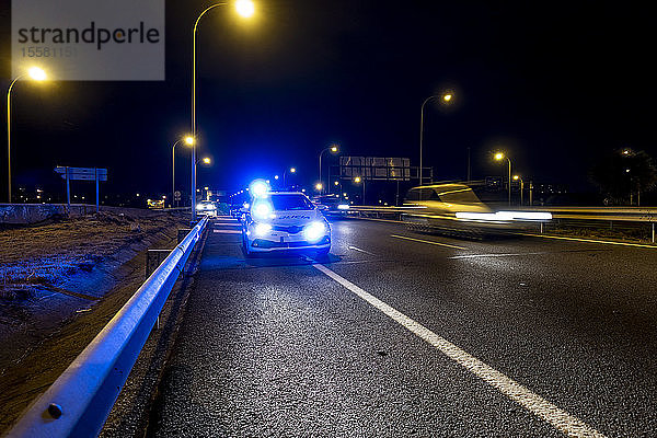 Beleuchtetes Polizeiauto auf der Straße von Madrid in der Nacht