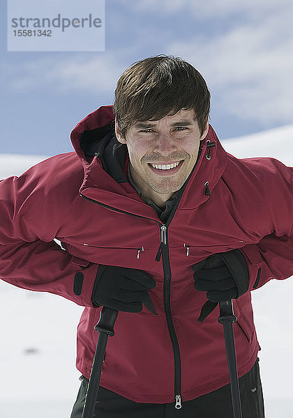 Österreich  Tirol  Junger Mann beim Skifahren  Porträt  lächelnd