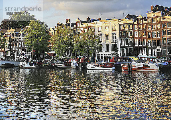 Niederlande  Amsterdam  Blick auf Häuser und Boot mit Amstelkanal