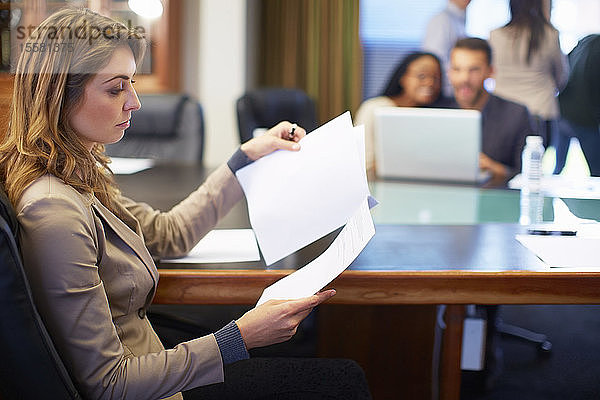 Geschäftsfrau liest Dokument im Sitzungssaal