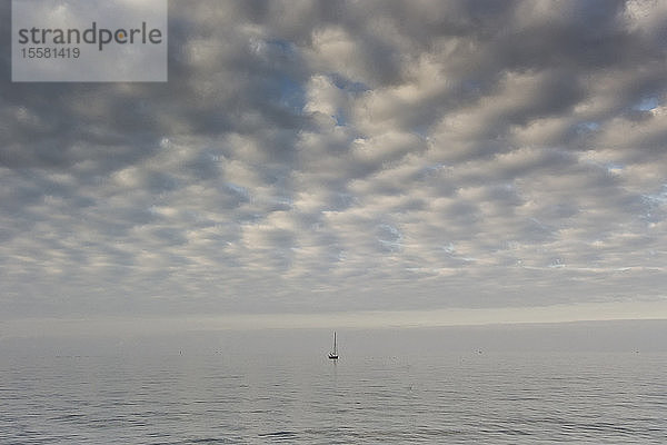 Deutschland  Ostsee  Segelboot ruht auf dem Meer unter bewölktem Himmel