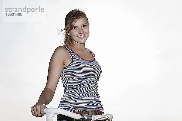 Deutschland  Köln  Junge Frau mit Fahrrad  lächelnd  Portrait