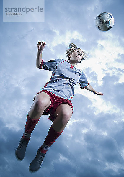 Deutschland  Augsburg  Fußballspieler springt in die Luft  um einen Ball zu köpfen