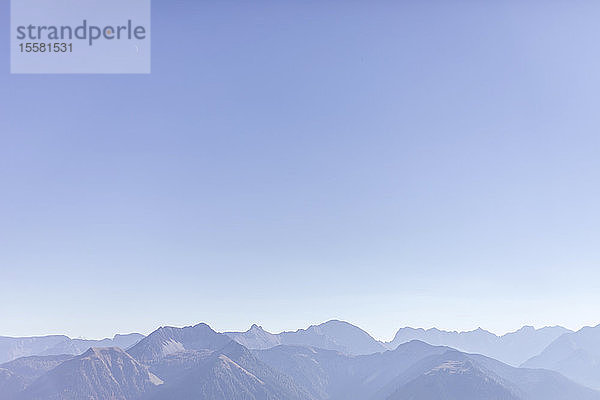 Blick auf das Karwendelgebirge vor klarem  blauem Himmel bei nebligem Wetter  Bayern  Deutschland