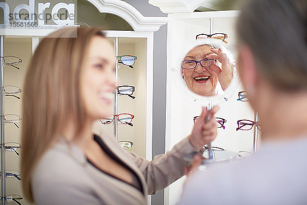 Optiker berät ältere Frau im Geschäft