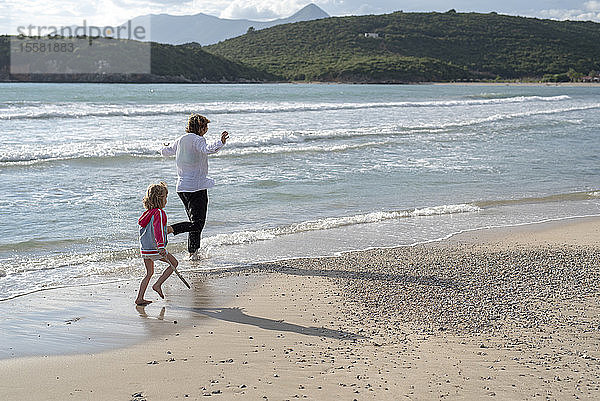 Griechenland  Parga  Mutter und Tochter laufen an der Strandpromenade