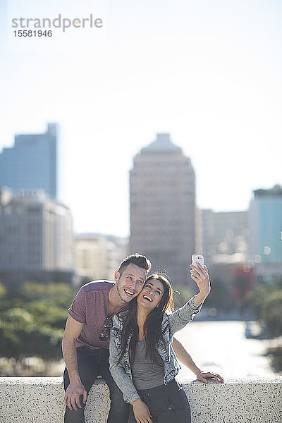 Glückliches junges Paar beim Selfie mit Smartphone