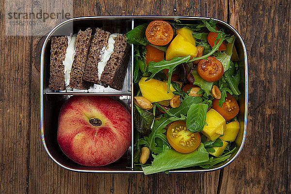 Direkt über dem Schuss einer gesunden Mahlzeit in einer metallischen Lunchbox auf dem Tisch
