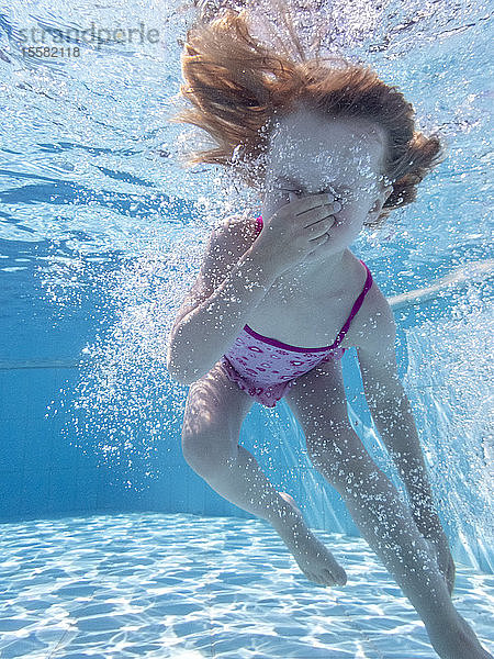 Kleines Mädchen unter Wasser im Schwimmbad