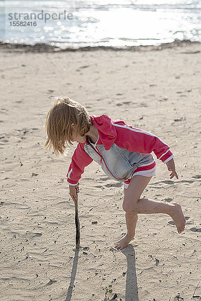 Griechenland  Parga  kleines Mädchen spielt mit einem Stock am Strand