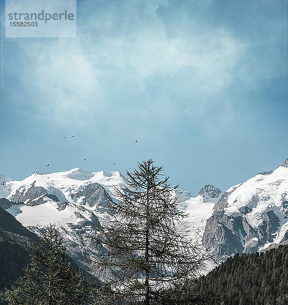 Landschaftliche Ansicht schneebedeckter Berge vor bewölktem Himmel in Italien