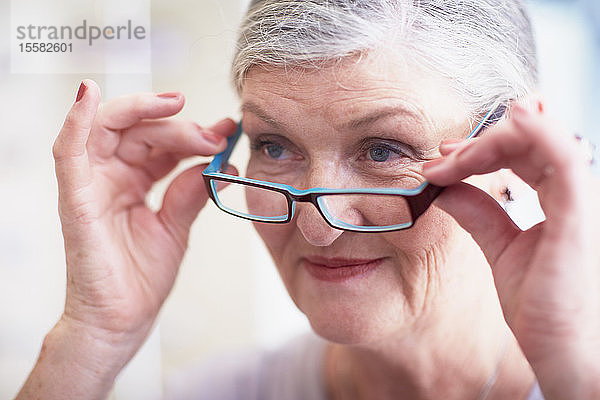 Ältere Frau beim Optiker bei der Brillenanprobe