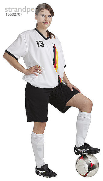 Porträt eines jungen Mädchens  das mit Fussball steht und lächelt