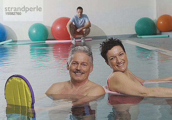 Deutschland  Nürnberg  Ehepaar im Pool mit Mann im Hintergrund