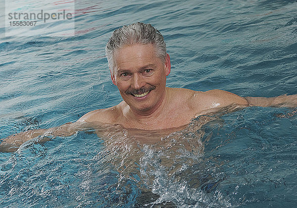 Deutschland  Nürnberg  Senior Mann im Schwimmbad  Porträt  lächelnd