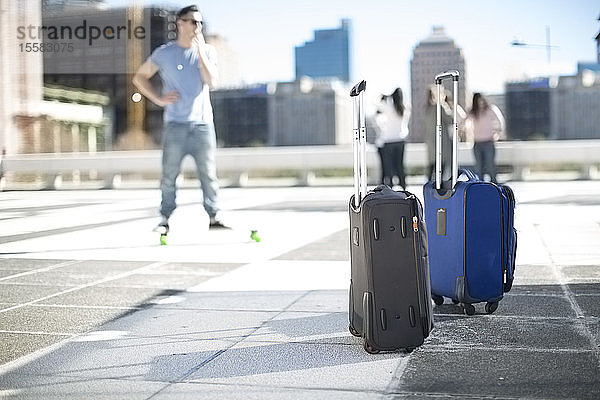 Freunde auf Städtereise mit rollenden Koffern