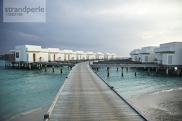 Abnehmende Perspektive des Piers  der zu den Villen über dem Meer auf den Malediven führt