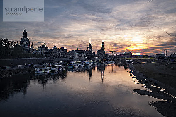 Boote liegen auf der Elbe gegen den Himmel in der Stadt bei Sonnenuntergang vor Anker  Sachsen  Deutschland