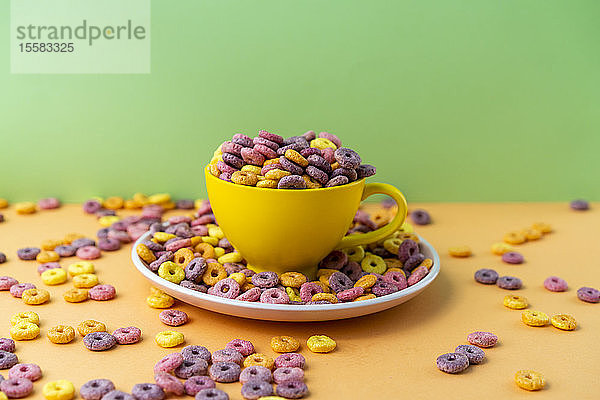 Tasse und Teller voller bunter Cerealien