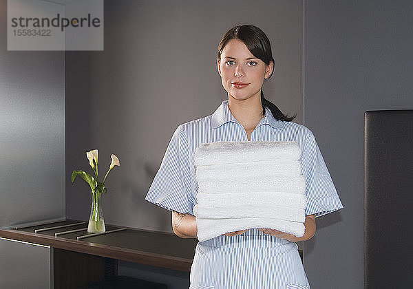 Deutschland  Zimmermädchen mit Handtüchern in einem Hotelzimmer