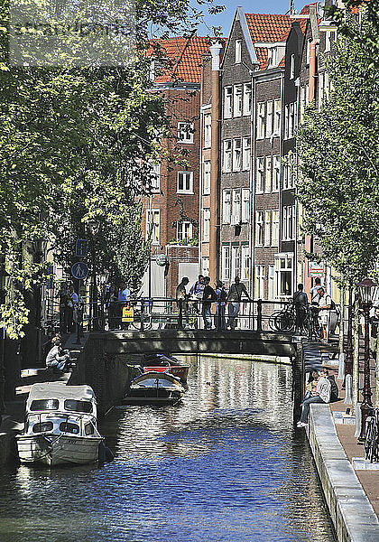 Niederlande  Amsterdam  Menschen auf kleiner Brücke über den Kanal