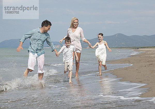 Spanien  Familie am Strand laufen