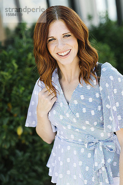 Lächelnde Frau im mittleren Erwachsenenalter mit gemusterter Bluse