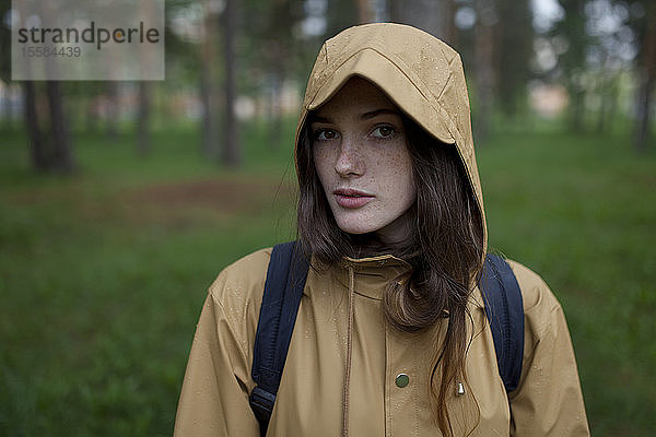 Porträt einer jungen Frau mit braunem Regenmantel