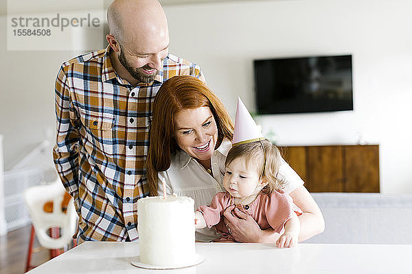 Eltern und Tochter mit Geburtstagstorte