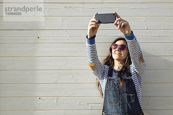 Frau mit Sonnenbrille macht Selfie